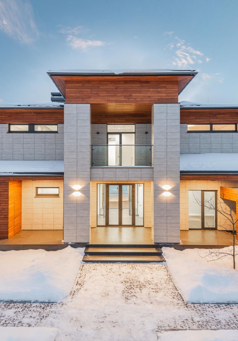 Façade d'une maison moderne avec bardage aluminium et bois, associée à des menuiseries extérieures vitrées pour un design contemporain en milieu enneigé Façade d'une maison moderne avec bardage aluminium et bois, associée à des menuiseries extérieures vitrées pour un design contemporain en milieu enneigé