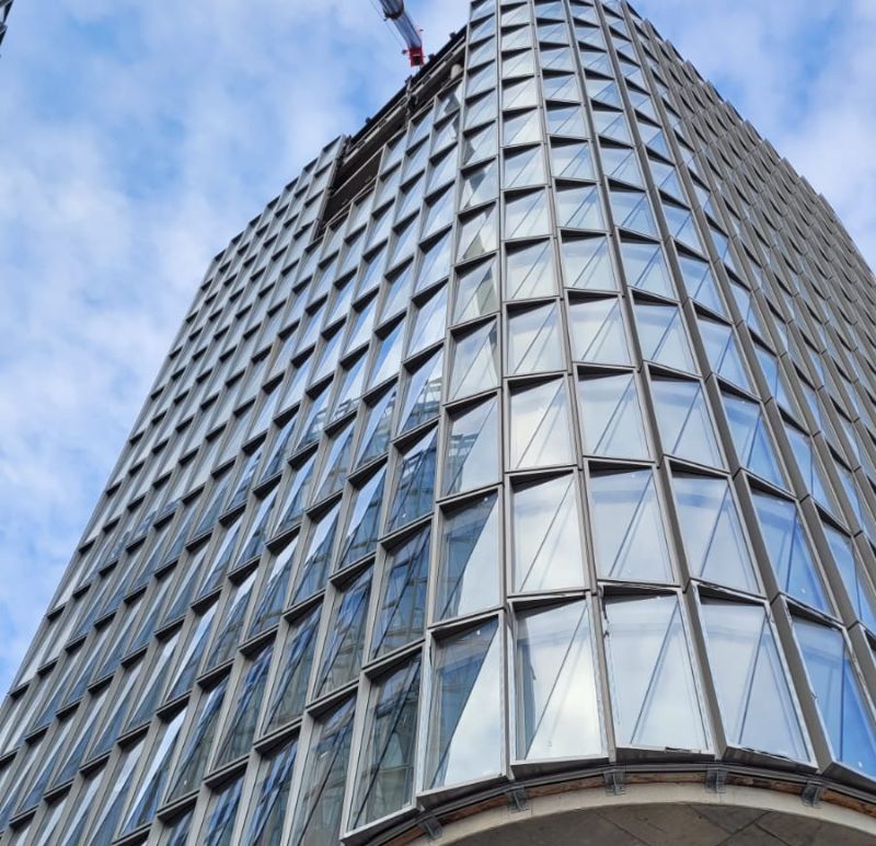 Façade vitrée d'un immeuble moderne avec structure en bardage aluminium, illustrant le montage précis de panneaux de verre sur une architecture contemporaine Façade vitrée d'un immeuble moderne avec structure en bardage aluminium, illustrant le montage précis de panneaux de verre sur une architecture contemporaine