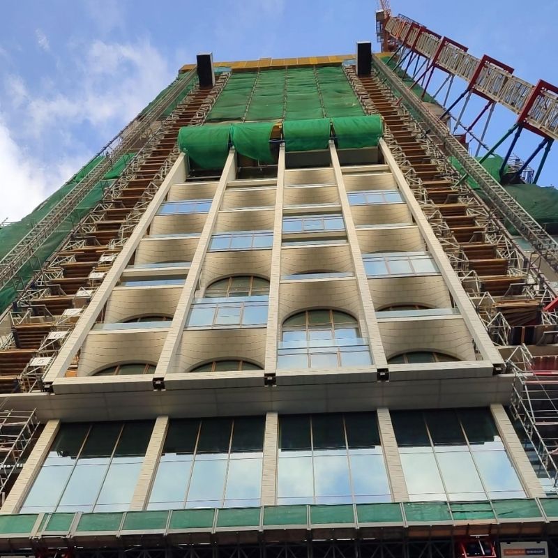 Facade being erected on the Post Rotterdam building, with scaffolding and fiber-reinforced concrete elements