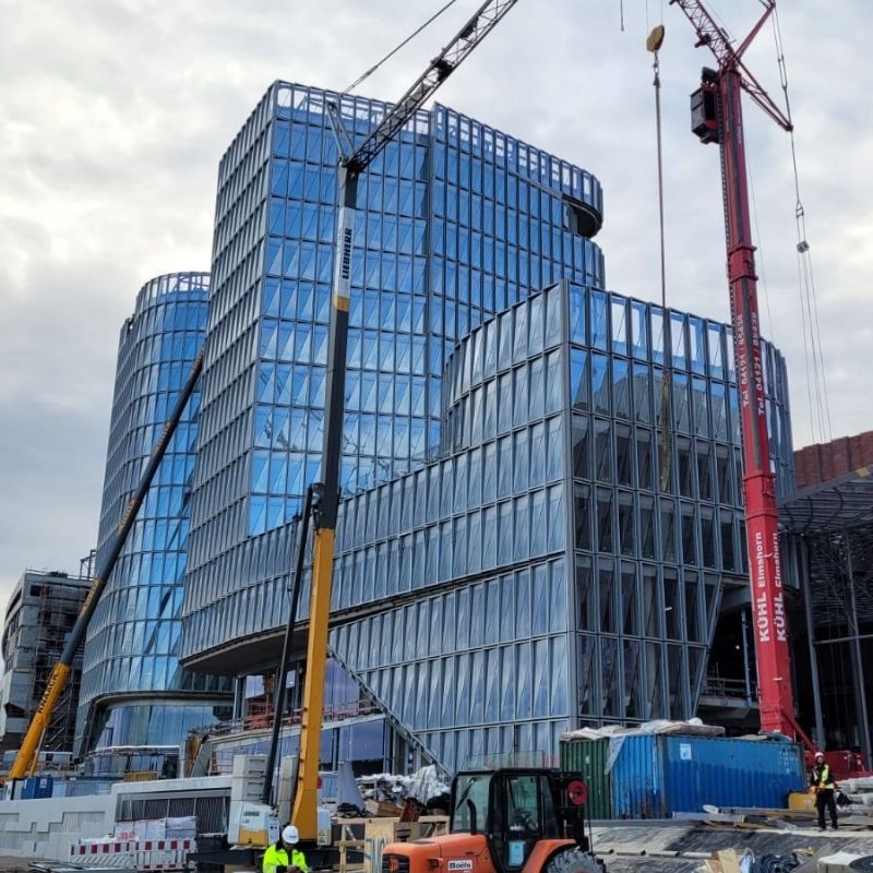 Overview of glazed Westfield Hamburg buildings with cranes and active building site
